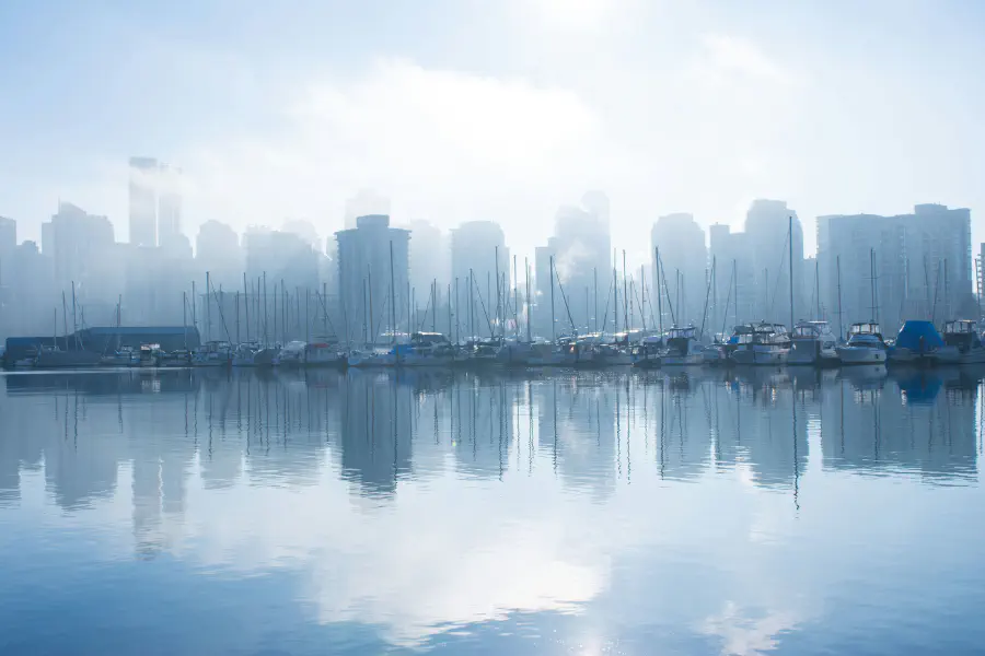 The Vancouver skyline reflected in water. The photo is toned with blue.