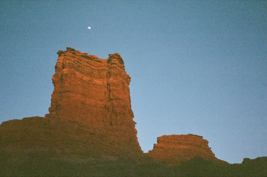 Red rocks in the desert underneath the rising moon.
