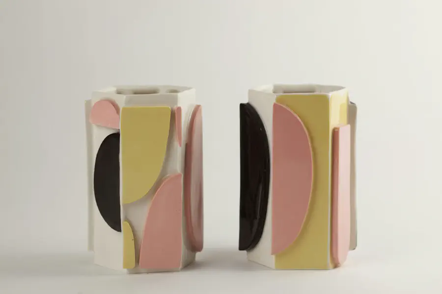 Three vases with panels added to the sides with yellow, pink, and black.