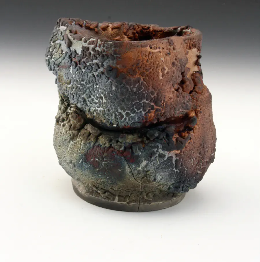 A warped vase that looks like the coating is burnt or flaking off.