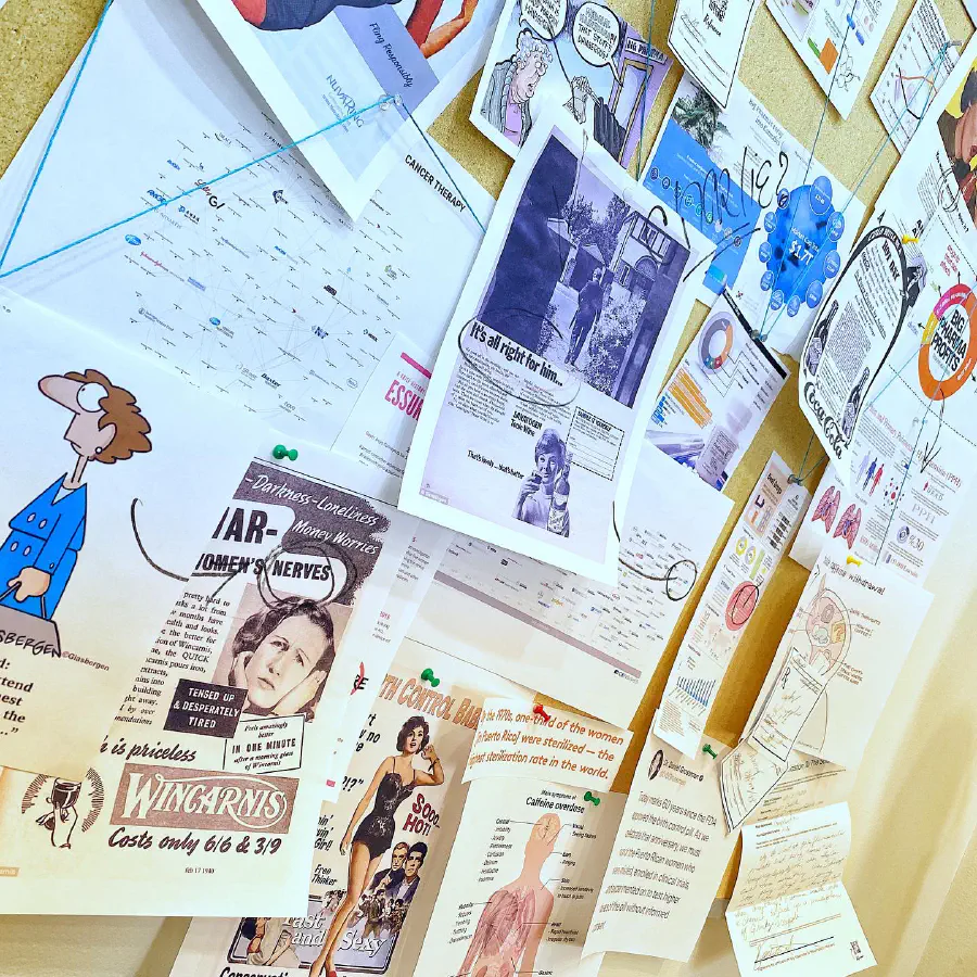 A closeup of the corkboard, showing cartoons, figures of women being gazed, a diagram about caffeine overdose, a notice about 1/3 of women in Puerto Rico being sterilized, and other political pieces of writing.