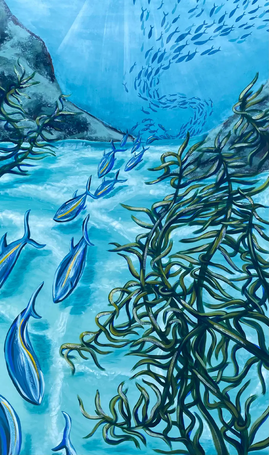 A canvas depicting an underwater ocean scene. Blue and yellow fish swim in a school, passing by kinetic, dark green algae.